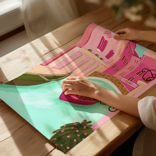 Illustrated art print of a vibrant Venice canal scene featuring pastel pink buildings, a turquoise canal, and a magenta gondola adorned with flowers, framed by lush greenery and ornate iron balconies.