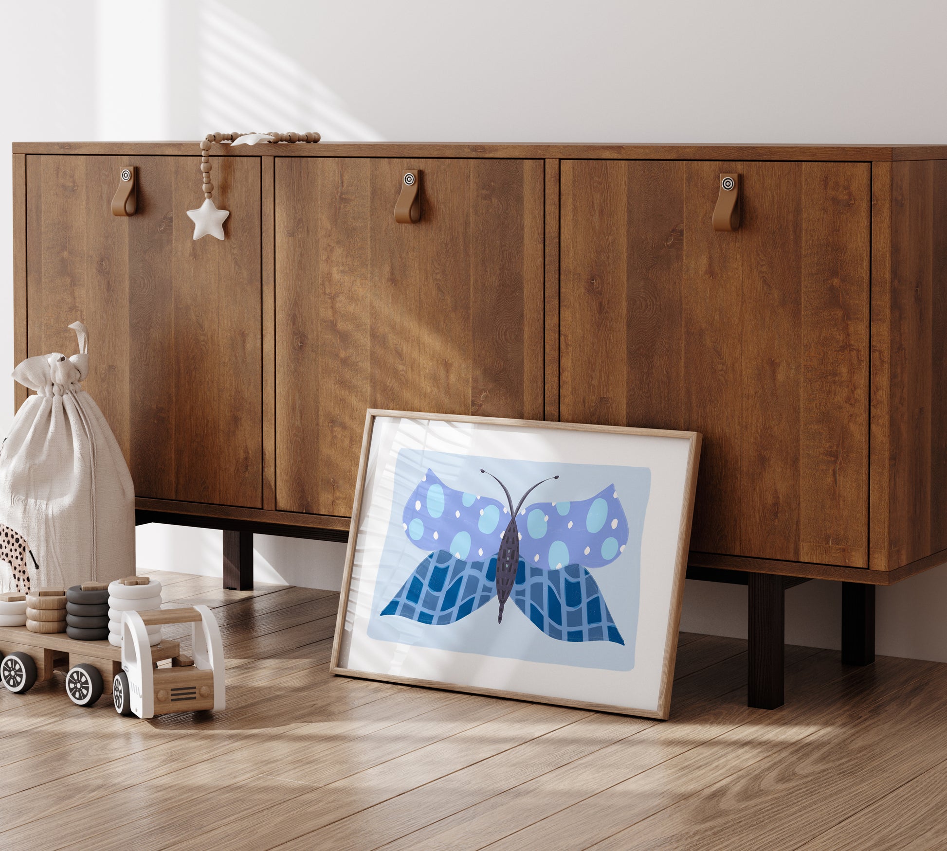 Wooden cabinet with a framed blue butterfly artwork on a wooden floor.