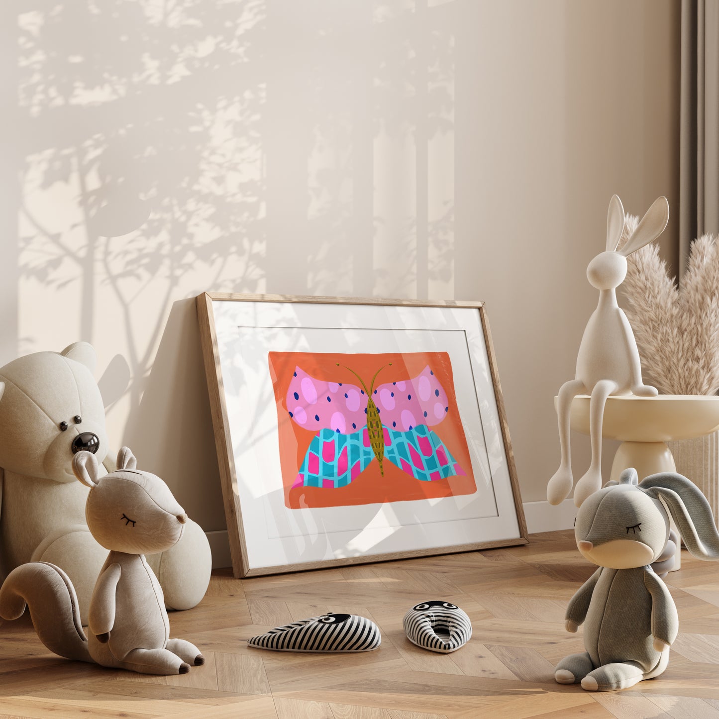 Framed children's artwork of a pink and blue butterfly on a shelf with toys and decorative items.