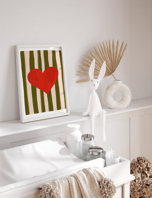 Decorative shelf with a framed heart art print, rabbit sculpture, and decorative items.