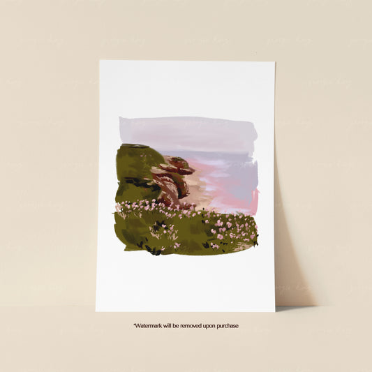High tide coastal landscape print featuring windswept trees, green clifftops and a soft pink sky beside the sea
