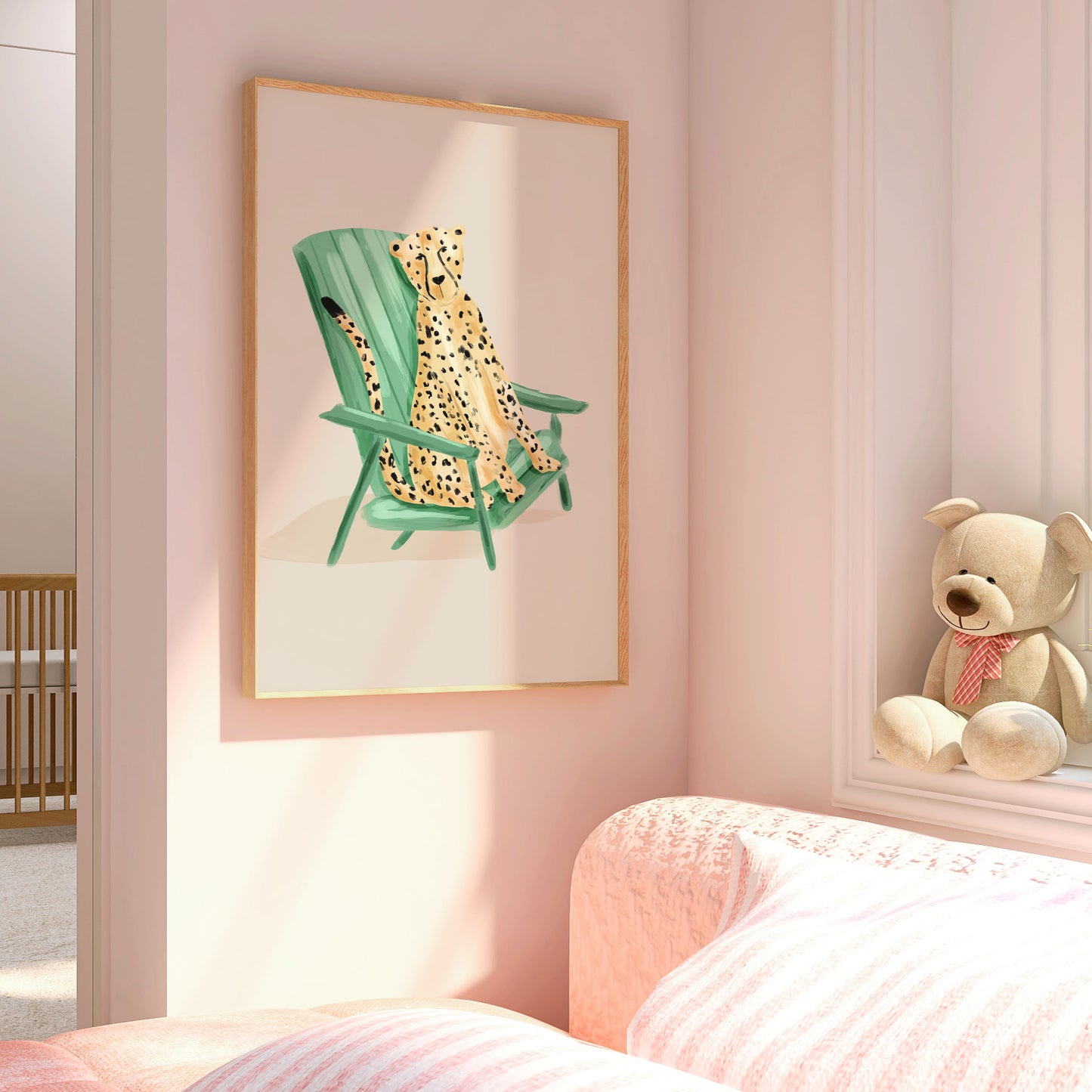 Framed artwork of a cheetah in a green chair on a pink wall above a bed with a teddy bear.