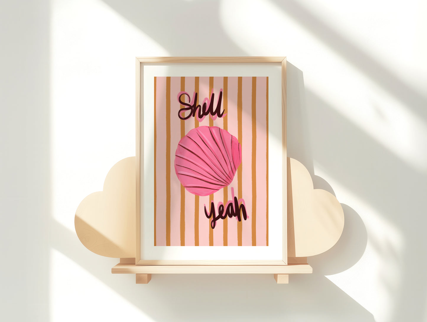 Framed artwork with a pink shell and text on a striped background, displayed on a white surface.